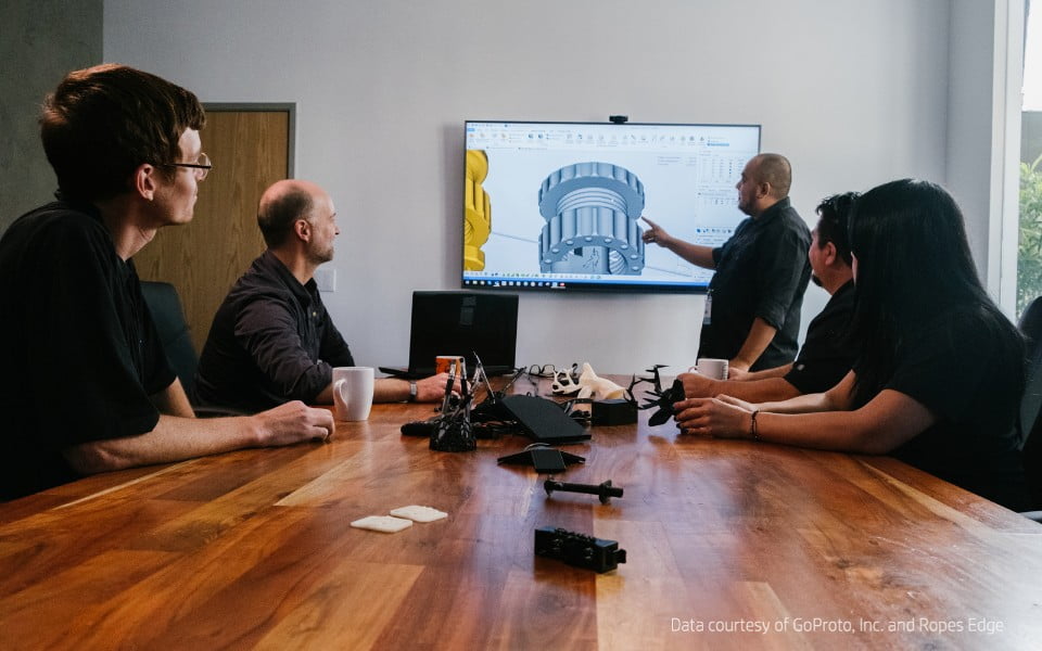 Designers at GoProto discuss a 3D prototype iteration as part of the rapid prototyping process.